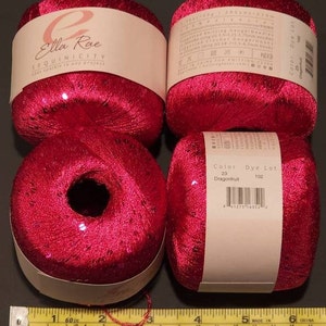 Pu&ograve; includere: Quattro rocchetti di filo rosa con paillettes. Il filo &egrave; etichettato "Ella Rae Sequinicity" e "Color 23 Dragonfruit, Dye Lot 102".