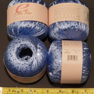 May include: Four skeins of blue yarn with silver sequins. The yarn is labelled "Ella Rue Sequinicity adds sparkle to any project". The label also includes the colour "Moonlight" and dye lot number 101.