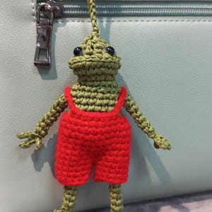 Chaveiro de crochê com pingente de bolsa de sapo feito à mão em macacão vermelho – Pingente de bolsa de animal fofo – Presente de sapo kawaii – Prendedor de mochila de amigurumi de sapo