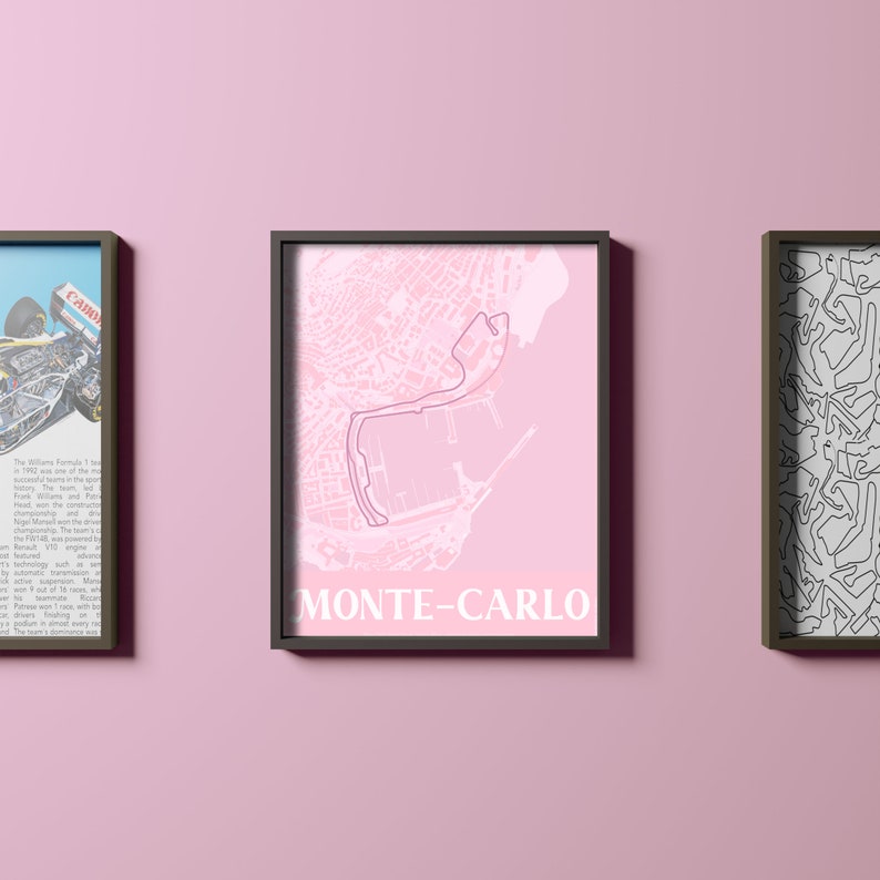 May include: A pink and white print of the Monte Carlo race track, framed in black. The print shows the track layout and surrounding city streets. The text "MONTE-CARLO" is printed in white at the bottom of the print.