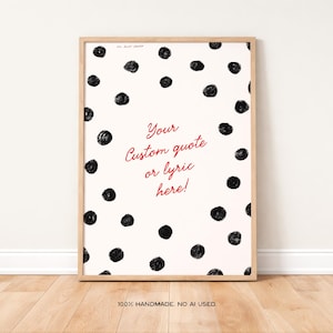 Könnte beinhalten: Ein gerahmter Druck mit cremefarbenem Hintergrund und verstreuten schwarzen Tupfen. Der Text "Your custom quote or lyric here!" ist in roter Schrift. Der Rahmen ist helles Holz. Der untere Teil des Drucks lautet "100% HANDMADE. NO AI USED."