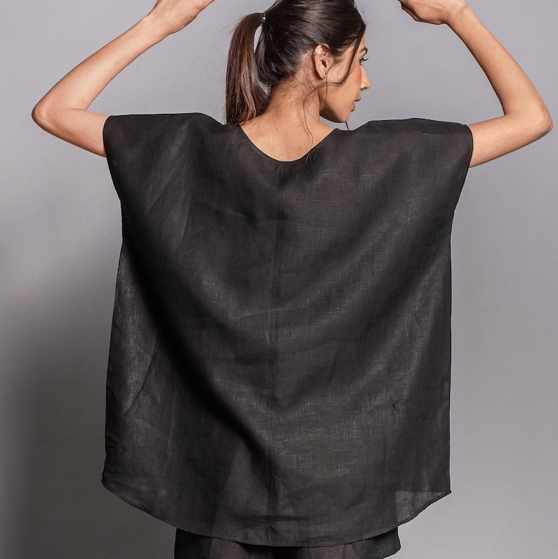 May include: A black linen top with a loose, flowing fit and a scoop neckline. The top is made of a lightweight, breathable fabric and has a relaxed, casual style.