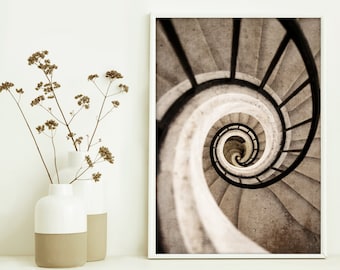 May include: A black and white photograph of a spiral staircase with a metal railing. The staircase is made of concrete and has a worn, aged look.