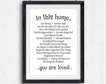 May include: A black framed print with a white background and black text that reads "In this home... You Belong You Are Safe You Are Accepted for Who You Are Your Individuality Is Recognised You Are Appreciated You Are Respected Your Opinion Counts Life Is Celebrated Life Has Purpose Curiosity Is Encouraged We Seek the Good in All Things We Rejoice in Each Others Successes People Are More Important Than Things There Is Always Room for Forgiveness Happiness Is Pursued Love Abides Change Is Embraced All Things Are Possible! ...you are loved"