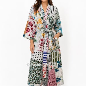 May include: A long-sleeved robe featuring a patchwork design with various floral, polka dot, and striped patterns in shades of red, blue, green, and yellow. The garment includes a matching tie belt at the waist and two side pockets.