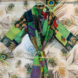 Puede incluir: Una bata kimono de patchwork verde, morado y marrón con cinturón de atar. La bata está hecha de una tela suave y acolchada y tiene un corte holgado.