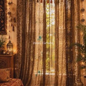 May include: A set of floor-length brown curtains with a tab-top header, featuring a sheer fabric with intricate floral patterns and metallic accents. A decorative garland of small tassels hangs across the top, and the text Zooey-Curtaibs is visible.