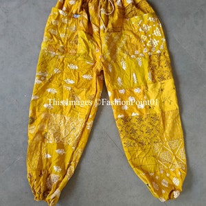 Könnte beinhalten: Gelbe Patchwork-Hose mit Kordelzugbund und elastischen Bündchen. Die Hose ist aus Baumwolle und hat verschiedene Muster, darunter Paisley- und Blumenmuster.