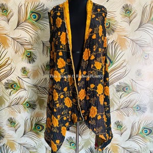 May include: A black and yellow floral print sleeveless jacket with a yellow trim. The jacket is made of a lightweight fabric and has a flowing, asymmetrical hem.