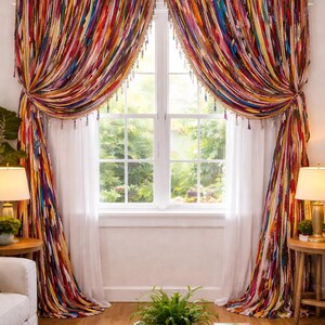 Puede incluir: Cortinas coloridas de estilo bohemio con rayas verticales en tonos rojos, naranjas, amarillos, azules y verdes. Las cortinas est&aacute;n atadas, revelando una cortina blanca transparente. La ventana est&aacute; enmarcada por una moldura blanca.