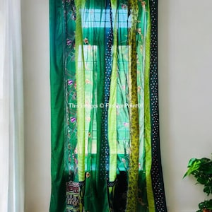 Peut inclure: Rideaux en patchwork vert avec un motif floral. Les rideaux sont faits de différents tissus et textures, et ils sont accrochés à un mur blanc.