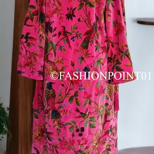Puede incluir: Una bata de terciopelo rosa con estampado floral y de p&aacute;jaros. La bata tiene mangas largas y una borla en el lateral.