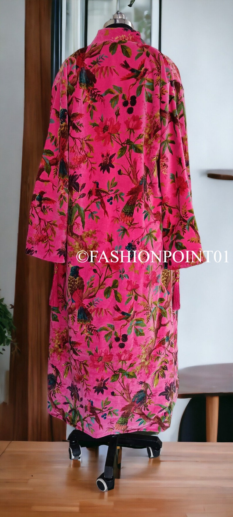 Puede incluir: Una bata de terciopelo rosa con estampado floral y de p&aacute;jaros. La bata tiene mangas largas y una borla en el lateral.
