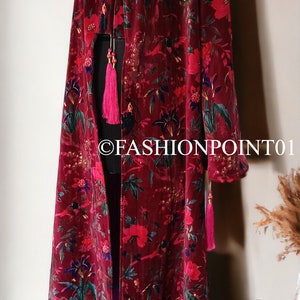 May include: A long, red velvet robe with a floral print and tassels. The robe is on a mannequin and has a  "FASHIONPOINT01" watermark.