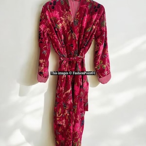 May include: A long, burgundy velvet robe with a floral pattern and a matching belt. The robe has long sleeves and a striped lining. The text "This images © FashionPoint01" is visible.