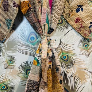 Puede incluir: Una bata de patchwork con una variedad de colores y patrones, incluyendo dise&ntilde;os florales, geom&eacute;tricos y paisley. La bata est&aacute; atada a la cintura y tiene mangas largas.