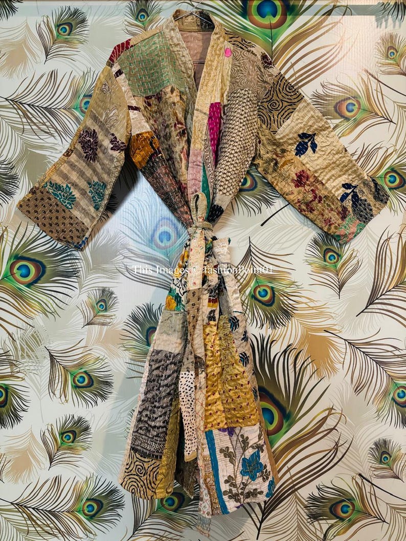 Puede incluir: Una bata kimono de patchwork con una variedad de colores y patrones, incluyendo marr&oacute;n, dorado, azul y verde. La bata est&aacute; hecha de seda y tiene un cierre de lazo.