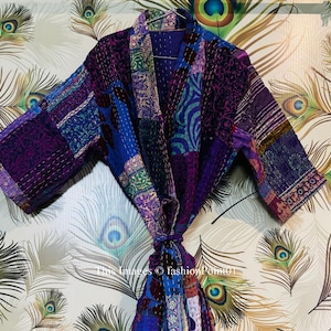 Könnte beinhalten: Eine violette und blaue Patchwork-Kimono-Robe mit Bindeverschluss. Die Robe ist aus weichem, gestepptem Stoff gefertigt und hat ein traditionelles japanisches Design.