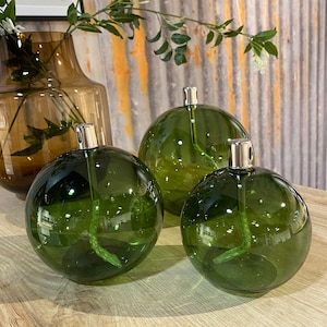 Modern glass oil lamp, transparent green colored sphere, living room decoration, cozy atmosphere