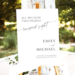 May include: White wedding welcome sign with black text that reads "All because two people swiped right."  The names Emily and Michael are listed below with the date August 24, 2023 and the location Any City, ST.