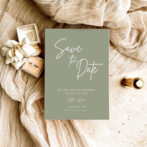 Może przedstawiać: Zielona karta z zaproszeniem na ślub z białą kaligrafią, która głosi "Save the Date". Karta zawiera również tekst "We are getting married August 24, 2020 Kate + Kevin New York, NW Formal invitation to follow."