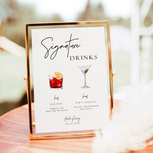 Może przedstawiać: Złoty znak z napisem "Signature Drinks" i ilustracjami dw&oacute;ch koktajli. Tekst "his" znajduje się obok koktajlu Negroni z wymienionymi poniżej składnikami. Tekst "hers" znajduje się obok koktajlu Dirty Martini z wymienionymi poniżej składnikami. Znak zawiera r&oacute;wnież tekst "Aufa Kinsey" i datę "08.25.20XX".