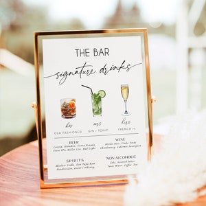 May include: A gold framed sign with the text "THE BAR signature drinks" at the top. The sign lists three signature drinks: "his" - Old Fashioned, "mrs" - Gin & Tonic, and "hers" - French 75. Below the signature drinks, the sign lists beer, wine, spirits, and non-alcoholic options.