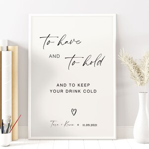 May include: A white printable sign with black text that reads "To have and to hold and to keep your drink cold."  The sign also includes a heart and the text "Tara + Kevin 11.09.2021".
