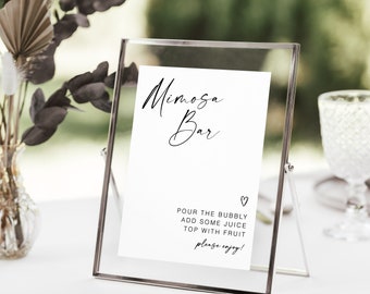 Może przedstawiać: Biały znak w srebrnej ramie z tekstem "Mimosa Bar" i instrukcjami do przygotowania mimosa: "Wlej szampana, dodaj trochę soku, udekoruj owocami, smacznego!"