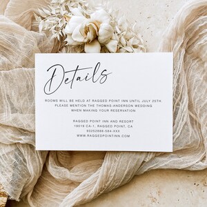 May include: A white card with black text that reads "Details" in cursive. The card provides information about a hotel, including the address, phone number, and website. The text reads: "Rooms will be held at Ragged Point Inn until July 25th. Please mention the Thomas-Anderson wedding when making your reservation. Ragged Point Inn and Resort 19019 CA-1, Ragged Point, CA 93252888-584-XXX www.raggedpointinn.com"