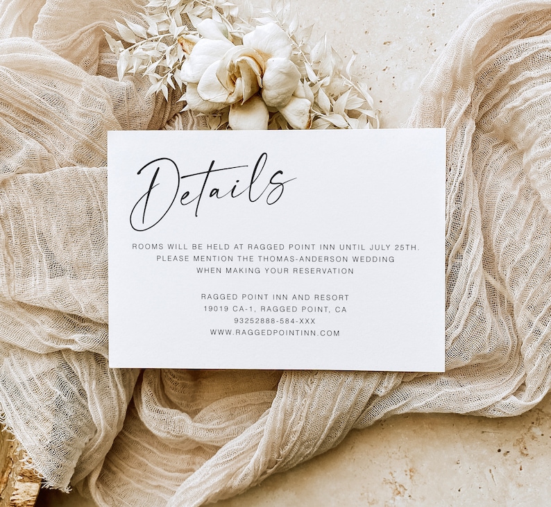 May include: A white card with black text that reads "Details" in cursive. The card provides information about a hotel, including the address, phone number, and website. The text reads: "Rooms will be held at Ragged Point Inn until July 25th. Please mention the Thomas-Anderson wedding when making your reservation. Ragged Point Inn and Resort 19019 CA-1, Ragged Point, CA 93252888-584-XXX www.raggedpointinn.com"