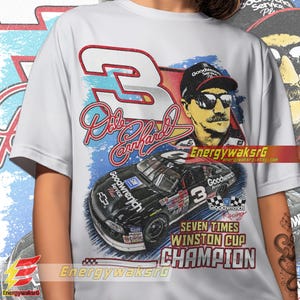 Pu&ograve; includere: Maglietta bianca con una grafica in stile vintage di Dale Earnhardt, la sua firma e la sua auto da corsa. La grafica presenta uno schema di colori blu, rosso e bianco con il testo "Goodwrench" e "Seven Times Winston Cup Champion".