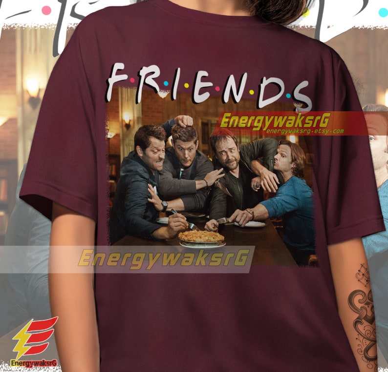 May include: A maroon t-shirt with the words "FRIENDS" in a colorful font, featuring a scene of four men sitting at a table with a pie. The men are all wearing casual clothing and have serious expressions on their faces.