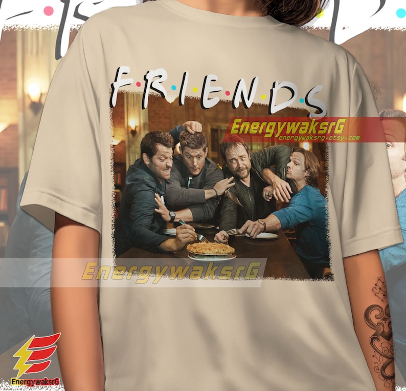 May include: A beige t-shirt with a vintage-style graphic of four men sitting at a table with a pie. The graphic includes the text "FRIENDS" with a black outline and colorful dots.