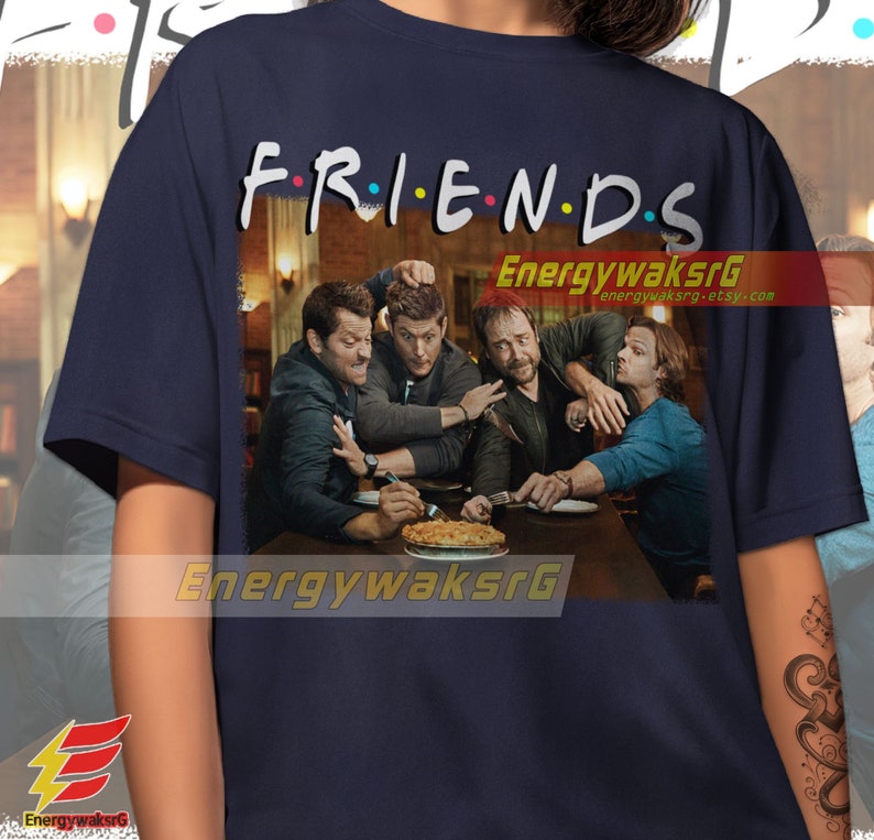 May include: A navy blue t-shirt with a graphic of four men sitting at a table with a pie. The text "FRIENDS" is above the graphic with colorful dots between the letters.