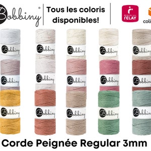 Op de afbeelding: Een assortiment kleuren van 3 mm dik katoenen touw, genaamd "Corde Peignée Regular 3mm", wordt in een rij weergegeven. Het touw is gemaakt door Bobbiny en is verkrijgbaar in verschillende kleuren.