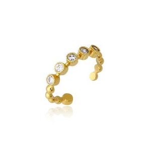 May include: A gold ring with a row of clear round stones set in a beaded band.