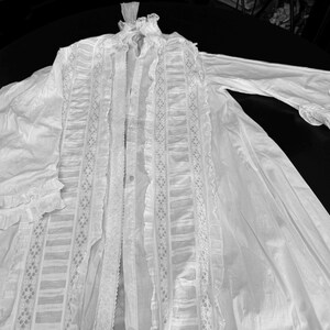 May include: A white cotton robe with lace trim and ruffles. The robe has a long, flowing silhouette and is perfect for lounging around the house.