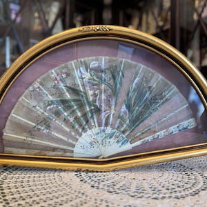 Antique fan, bone and hand painted fabric. Antique fan in a gold box.
