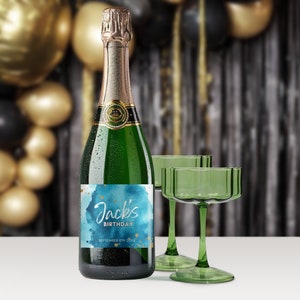 May include: A green glass bottle of champagne with a blue and gold watercolor label that says "Jack's Birthday September 8th 20XX".