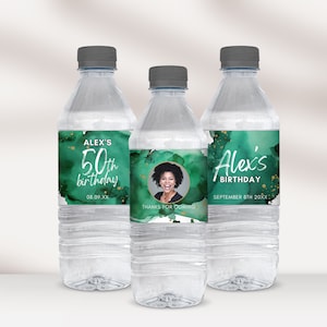 May include: Three clear plastic water bottles with personalized labels for a 50th birthday party. The labels feature a green watercolor background with gold glitter accents and a photo of the birthday person. The text on the labels reads "Alex's 50th birthday" and "Alex's Birthday".