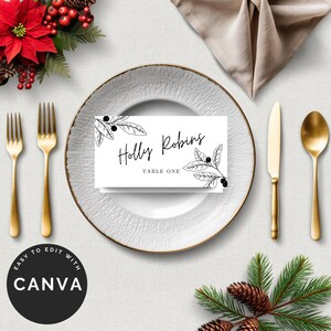 May include: A place setting with a white plate, gold utensils, and a folded napkin. A white place card with the name "Holly Robins" and botanical illustrations sits on the plate. The words "Easy to edit with Canva" are in a black circle.