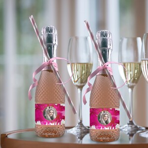May include: Two small bottles of pink champagne with personalized labels. The labels feature a watercolor design with a photo of a person and the text "Thanks for coming". Each bottle has a pink and white striped straw and a pink ribbon.