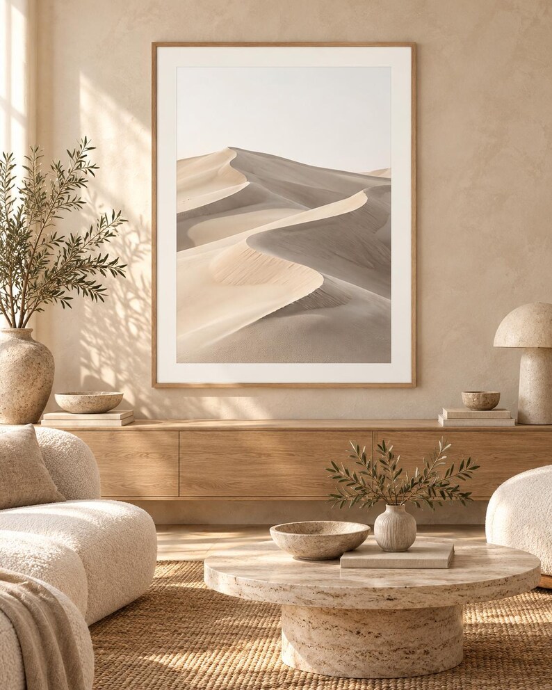 May include: A framed wall art print featuring a desert landscape with rolling sand dunes in shades of beige, tan, and soft gray. The image displays a high-contrast view of sunlit ridges and deep shadows across the sandy terrain.