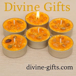 May include: Six orange-coloured candles with embedded stones and a lit wick. The candles are in silver metal containers. The text "Divine Gifts" is at the top, and "divine-gifts.com" is at the bottom.