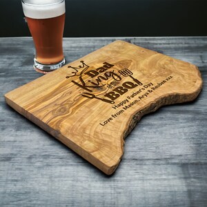 King of the BBQ olive wood chopping board personalised with any name the photo shows Dad as the name
