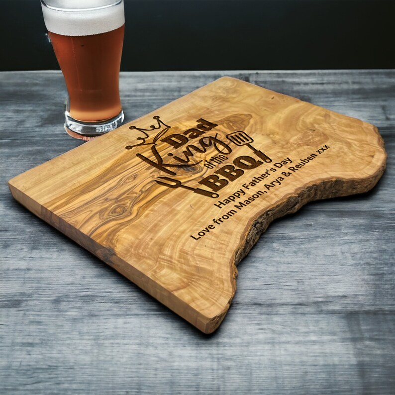 King of the BBQ olive wood chopping board personalised with any name the photo shows Dad as the name