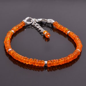 Puede incluir: Un brazalete de cadena de plata con cuentas de ópalo naranja. El brazalete tiene un cierre de mosquetón.