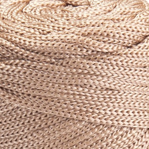 May include: A close-up of a beige braided rope, showing the intricate woven pattern.