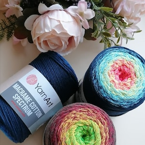 Könnte beinhalten: Drei Knäuel Garn in verschiedenen Farbkombinationen. Das Garn ist mit "Macrame Cotton Spectrum" und "YarnArt" beschriftet.